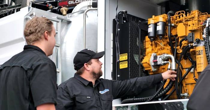 PS Equipment technicians inspecting a Caterpillar engine on a pump truck.
